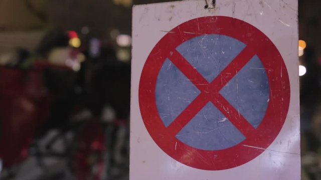 No parking sign with traffic in the background and a chariote passing