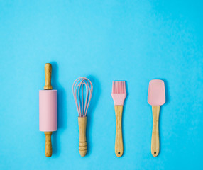 baking or pastry pink tools on blue background , flat lay , top view , with copy space 