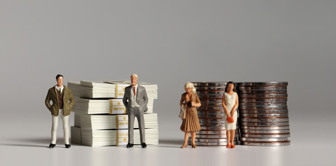 A pile of hundred dollar bills and coins with miniature people. The concept of a pay gap between...