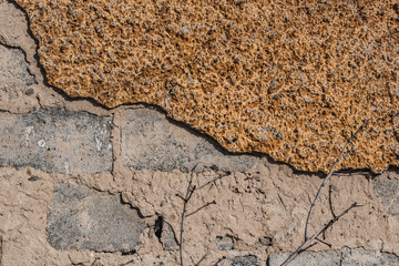 A beautiful horizontal texture of part of an old crashed gray brick wall with yellow plaster on the photo