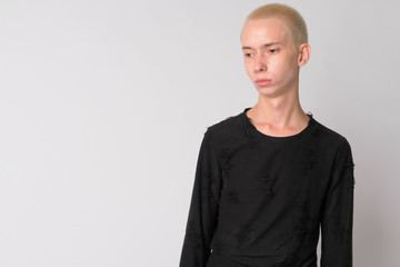 Portrait of young androgynous man thinking and looking down