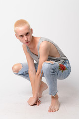 Fototapeta na wymiar Full body shot of young handsome androgynous man crouching