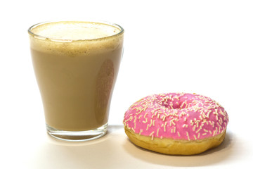 Transparent glass cup with coffee and pink donut on white background. Bright tone, soft focus