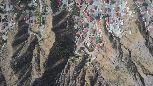 Overhead aerial view of an old spanish town close to a big mountain in the desert.