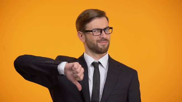Upset businessman showing thumbs down, unprofitable investment, unemployment
