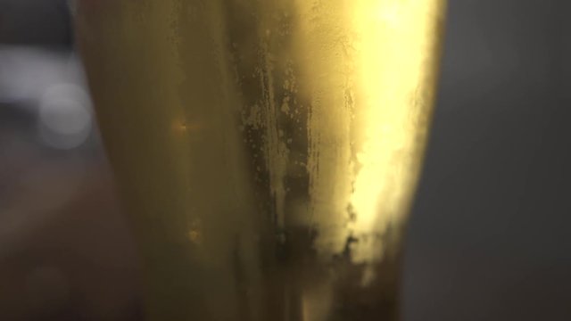 Cold beer in glass with air bubbles in bar pub close up. Lager beer in glass standing on table in bar.