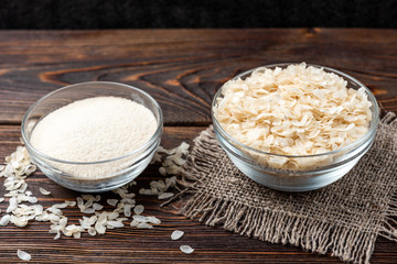 Rice on dark wooden background.