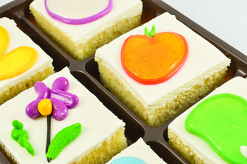 Close up of slice cake piece with cream and Jelly on top in cake box isolated on white background