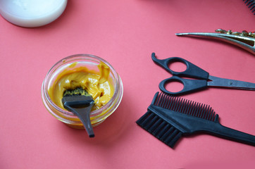 Barber shop set with hair dye, hairbrush, scissors, spray and brush on pink red background