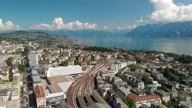 Beautiful aerial drone shot flying above the train station of Lausanne Switzerland with lake Geneva in the background