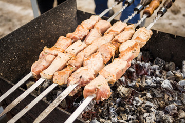 Georgian shish kebab. Meat on the coals. Brazier with fire. Folk cuisine. Meat on skewers. Coal and smoke.