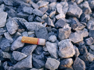 Close-up Burnt Cigarette Leftover on Small Stones