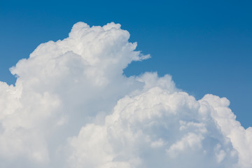 Naklejka na ściany i meble fluffy white cloud above clear blue sky background