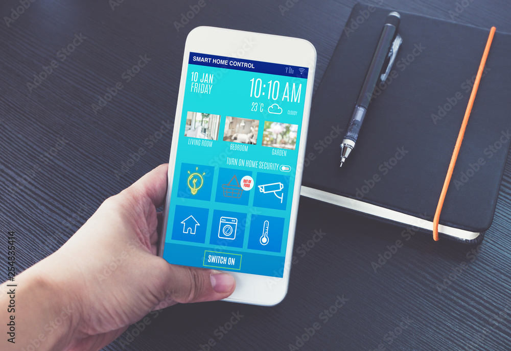 Poster Hand holding mobile with home control app on black table when working.Smart home control with iot concept.