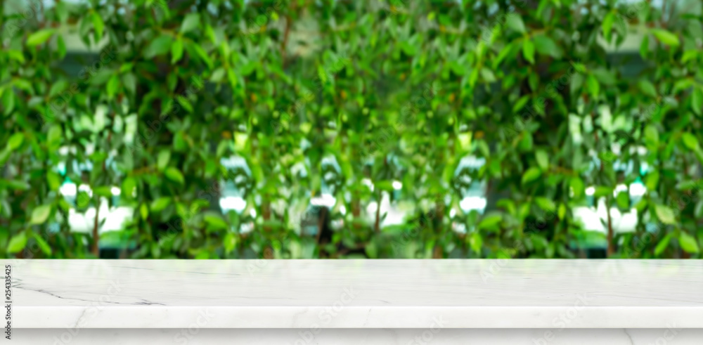 Poster empty marble table with green blur leaf wall garden background mock up for display or montage of pro