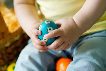 The child's hand with Easter painted eggs.