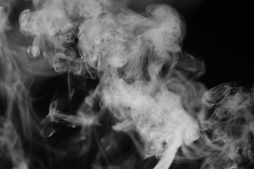 White smoke on a black background. Texture of smoke. Clubs of white smoke on a dark background for an overlay