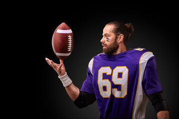 american football player throwing ball on black background