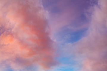 Cielo azul con nubes anaranjadas al atardecer.