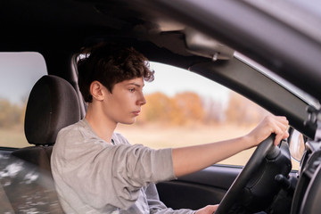 young male kid driver in car