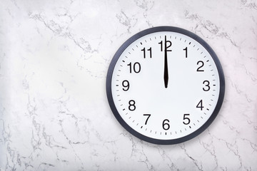 Wall clock show the twelve o'clock on white marble texture. Office clock show midday or midnight on...