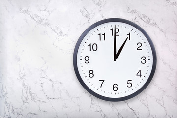 Wall clock show one o'clock on white marble texture. Office clock show 1pm or 1am on marble...