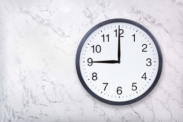 Wall clock show nine o'clock on white marble texture. Office clock show 9pm or 9am on marble...