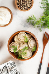 Boiled homemade dumplings with herbs in wooden plates
