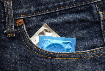 Condoms package in pocket blue jeans / Prevent Pregnancy or sexually transmitted disease concept