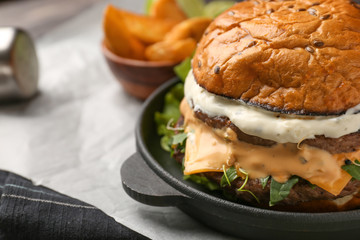 Pan with tasty burger on table, closeup