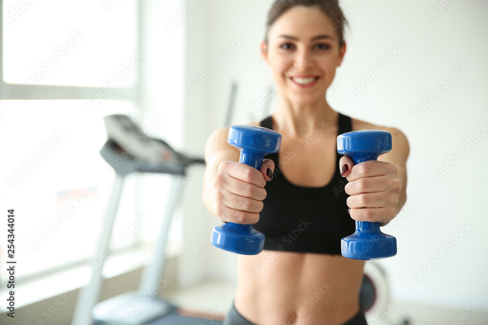 Poster Sporty young woman training in gym