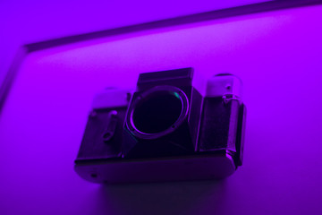 Old camera. Antique thing. Film camera. The camera in an unusual lighting.