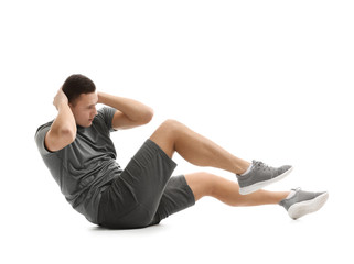 Sporty young man training against white background