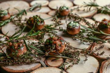 Tasty stuffed mushrooms with herbs on wooden table