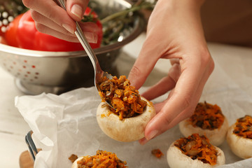 Woman cooking tasty stuffed mushrooms, closeup