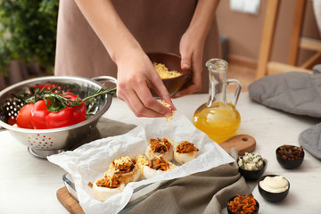 Woman cooking tasty stuffed mushrooms in kitchen