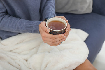 Young woman drinking hot tea at home