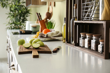 Fresh apple with cutting board on counter in kitchen