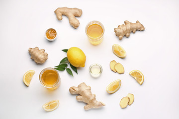 Glasses of healthy drink with ginger and lemon on white background