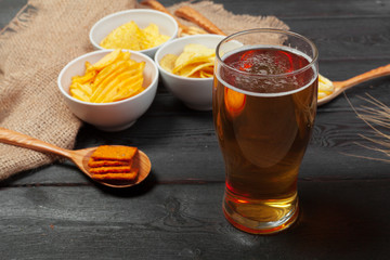 Lager beer and snacks on wooden table.
