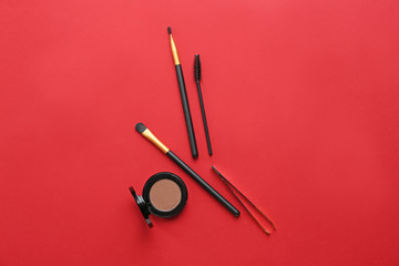 Set of tools for eyebrows correction and eyeshadows on color background