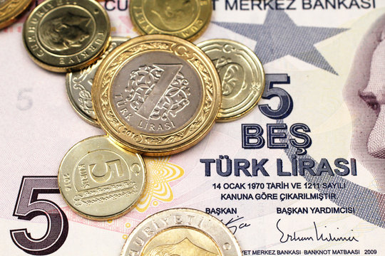 A macro image of an assortment Turkish coins close up on a purple, five Turkish lira bank note