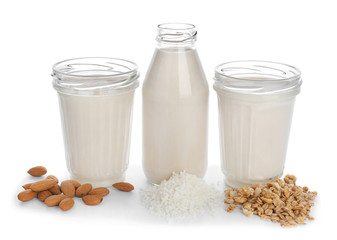 Glassware of different vegan milk on white background