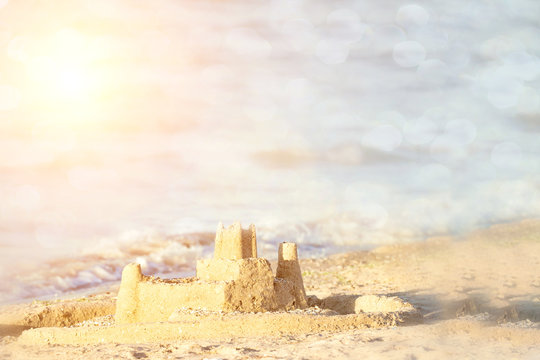 Holiday concept with sandcastle on the seaside. Summer background with copy space