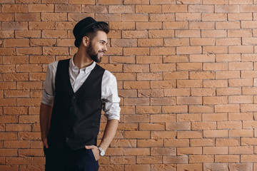 Fashionable young man near brick wall