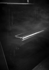 Piano in smoke on the dark background