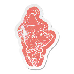 cartoon distressed sticker of a bear showing teeth wearing santa hat