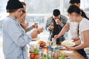 Young volunteers giving food to poor people