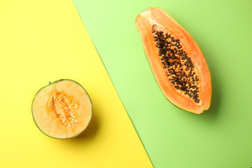 Tasty cut melon and papaya on color background