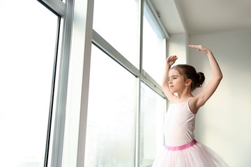 Cute little ballerina in dance studio